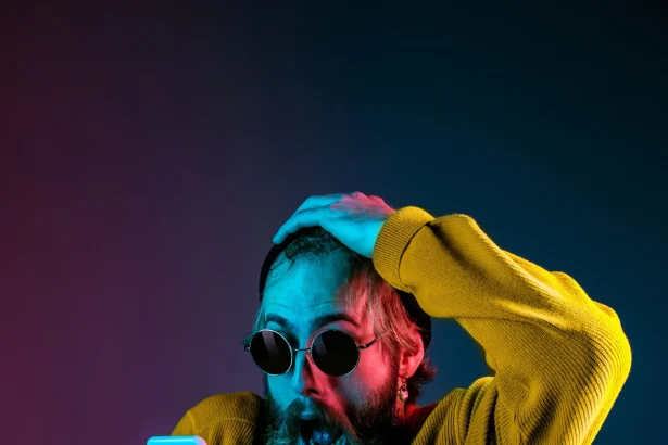 Caucasian man's portrait isolated on gradient studio background in neon light